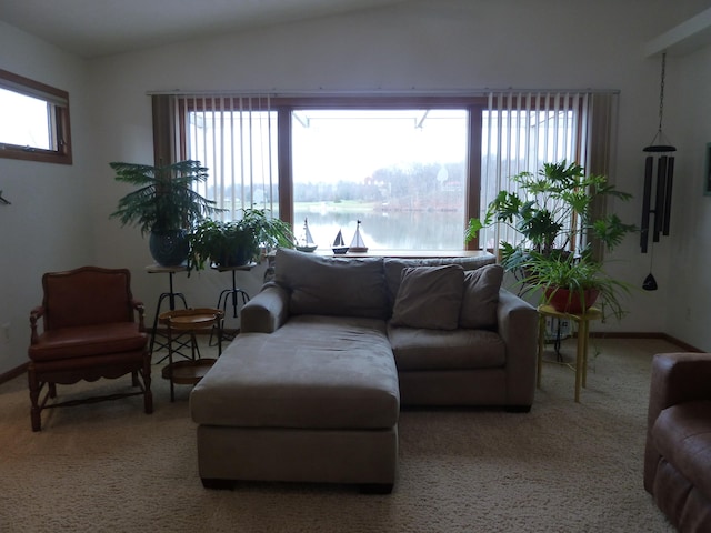 living room with a water view, light colored carpet, and lofted ceiling