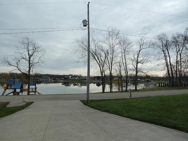 surrounding community featuring a water view, a playground, and a yard