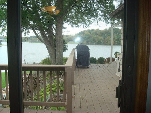 wooden terrace featuring a water view and area for grilling