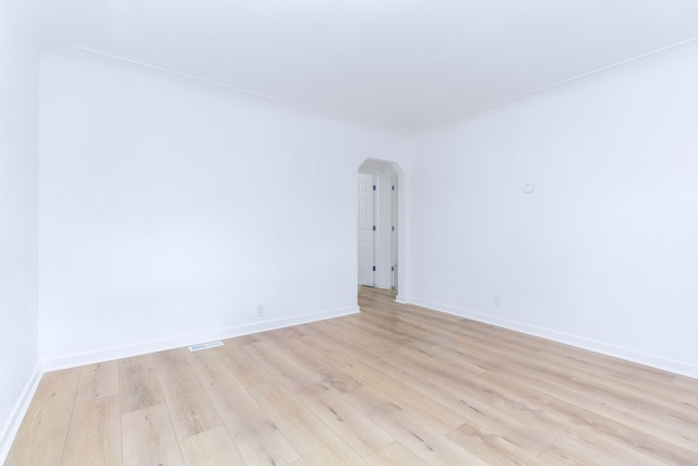 7641 Westminster Ave, Warren, MI 48091 - spare room featuring arched walkways, light wood-style floors, and baseboards