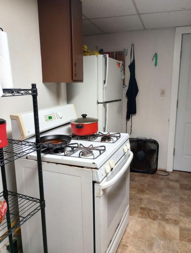 kitchen with white appliances and a paneled ceiling