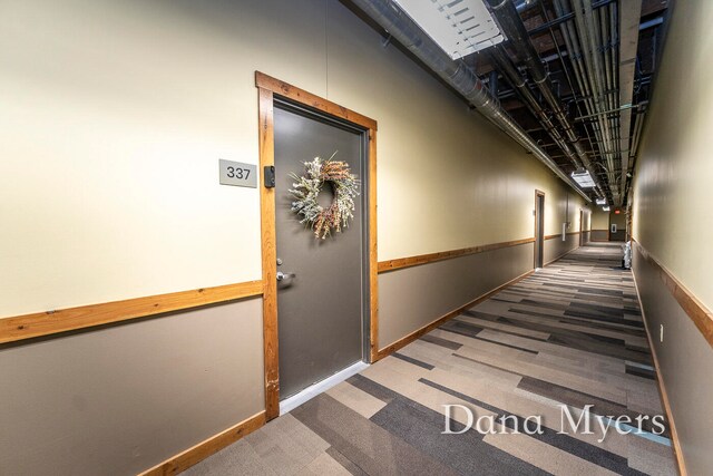 corridor featuring dark carpet