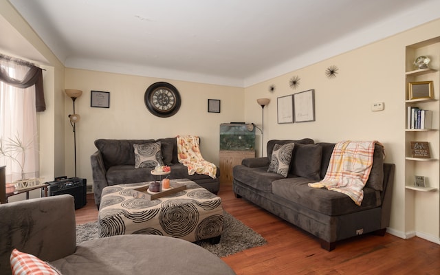 living room featuring built in features and dark wood-type flooring