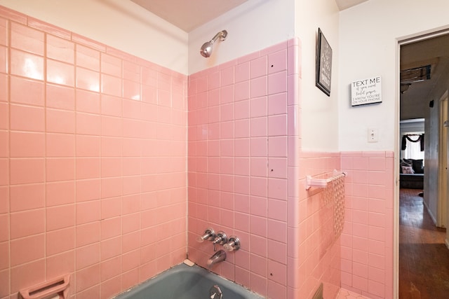 bathroom with tiled shower / bath and tile walls