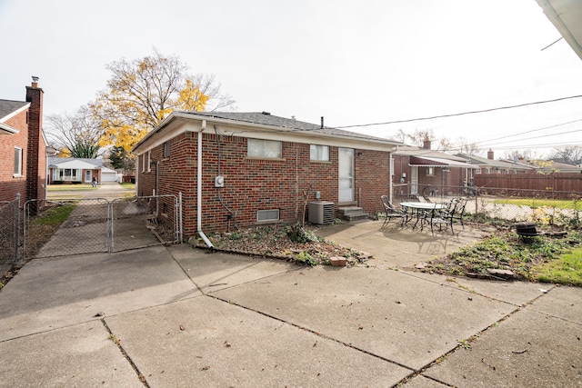 rear view of property with central AC unit and a patio area