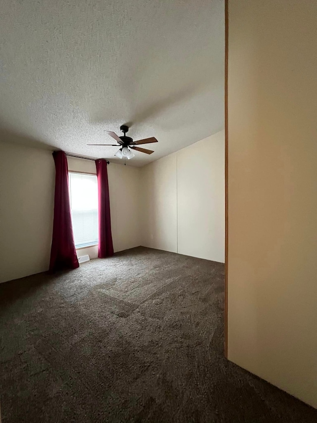 carpeted empty room featuring ceiling fan and a textured ceiling