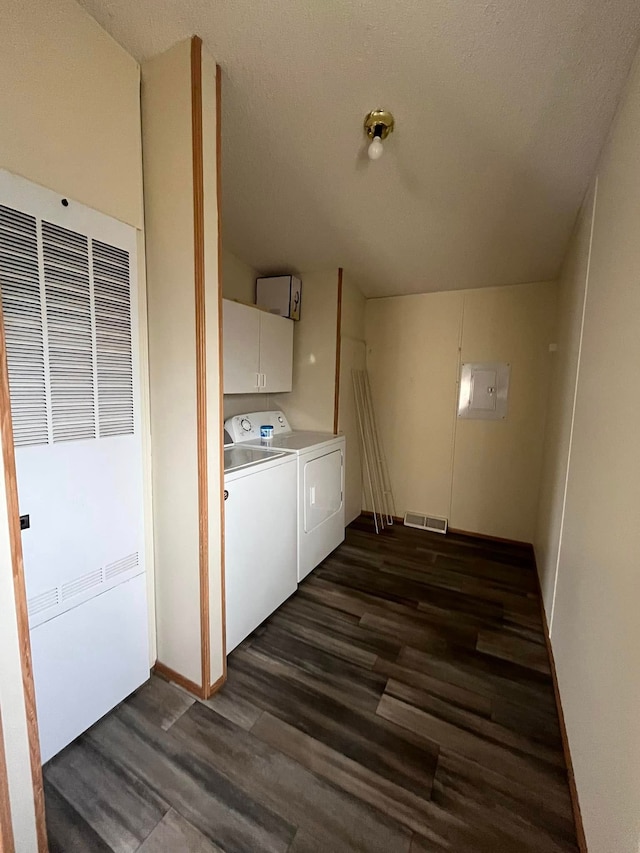 clothes washing area featuring cabinets, washer and dryer, dark hardwood / wood-style flooring, and a textured ceiling