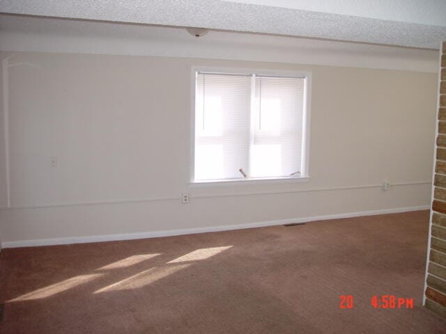 spare room featuring dark colored carpet