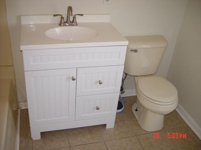 bathroom with tile patterned flooring, vanity, and toilet