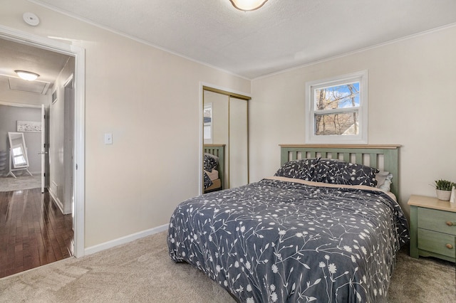 carpeted bedroom with a closet, a textured ceiling, and ornamental molding