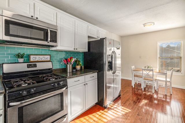 kitchen featuring backsplash, light wood-type flooring, white cabinetry, and stainless steel appliances