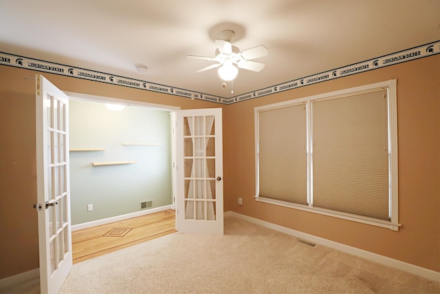 interior space with ceiling fan, light colored carpet, and french doors