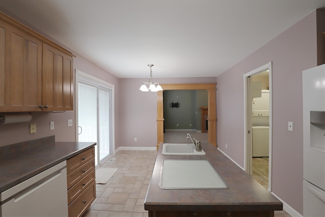 kitchen featuring sink, hanging light fixtures, white appliances, and an inviting chandelier