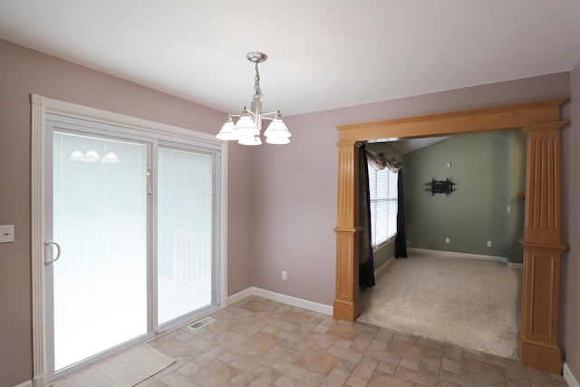 carpeted spare room with an inviting chandelier