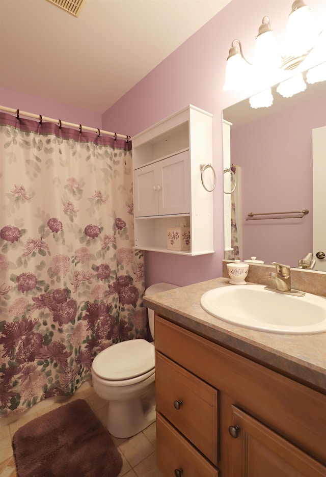 bathroom featuring tile patterned floors, curtained shower, vanity, and toilet