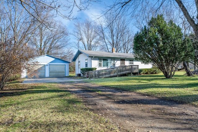 ranch-style home featuring a garage, a wooden deck, an outbuilding, and a front yard