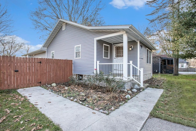 bungalow-style home with covered porch and a front yard