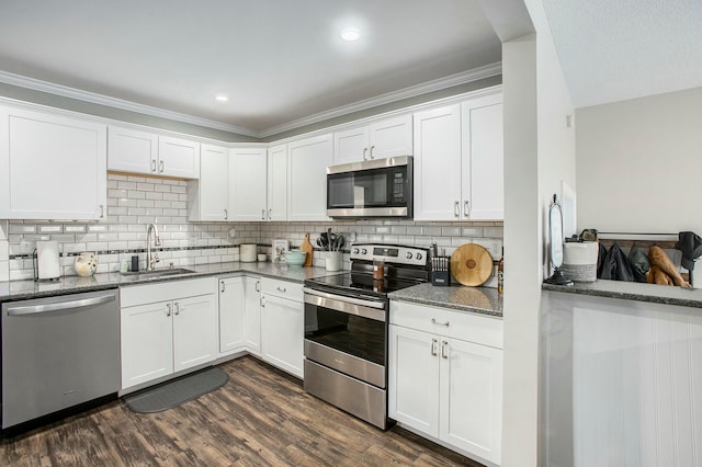 kitchen with dark stone counters, sink, dark hardwood / wood-style flooring, white cabinetry, and stainless steel appliances