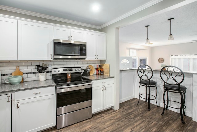 kitchen featuring appliances with stainless steel finishes, dark hardwood / wood-style floors, white cabinetry, and hanging light fixtures