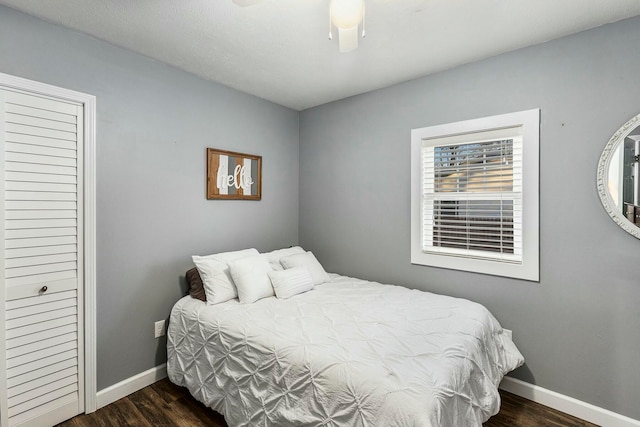 bedroom featuring ceiling fan, a closet, and dark wood-type flooring