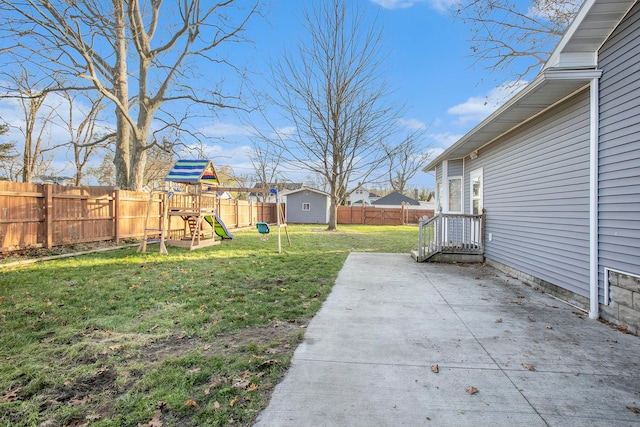 view of yard featuring a playground, a patio, and a shed