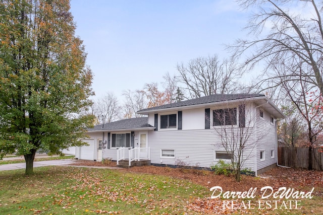 tri-level home with a garage and a front yard