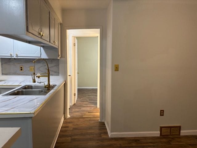 kitchen featuring decorative backsplash, dark hardwood / wood-style flooring, and sink