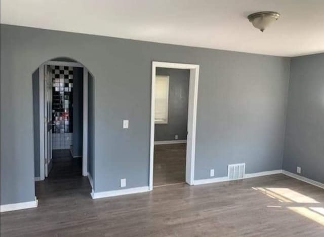 empty room with dark hardwood / wood-style flooring