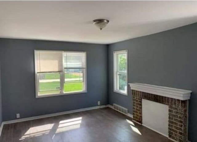 unfurnished living room with a fireplace and dark wood-type flooring