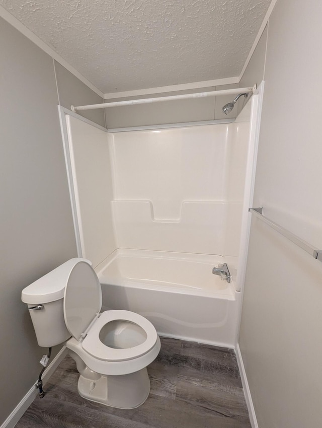 bathroom with toilet, bathtub / shower combination, a textured ceiling, and hardwood / wood-style flooring