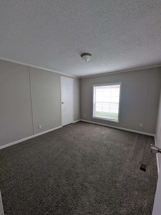 unfurnished room featuring dark carpet and a textured ceiling