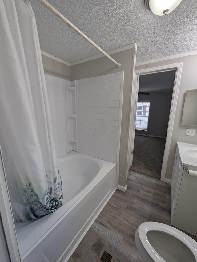 full bathroom featuring shower / bathtub combination with curtain, wood-type flooring, a textured ceiling, and ornamental molding