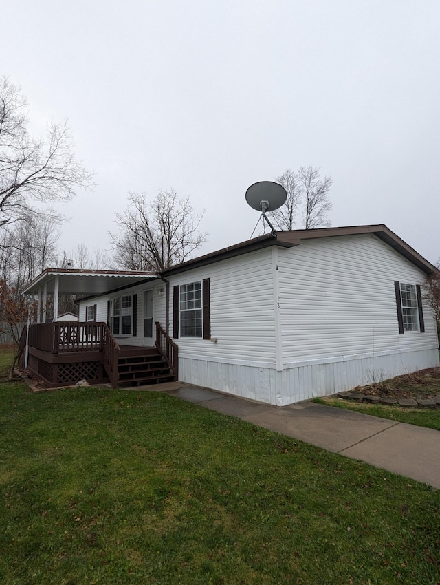 rear view of property with a wooden deck and a lawn