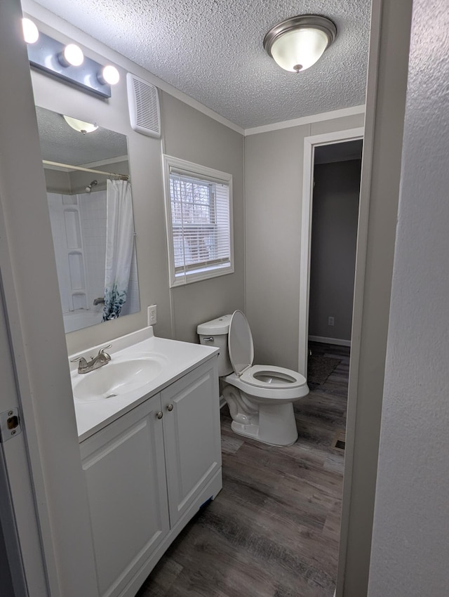 bathroom with a shower with shower curtain, vanity, crown molding, wood-type flooring, and toilet