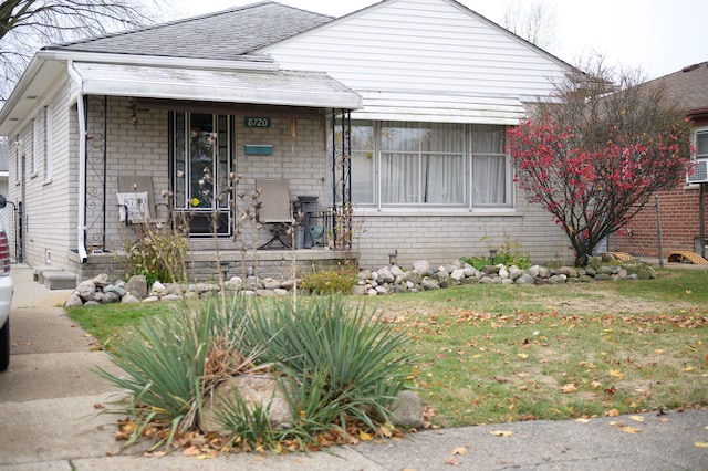 bungalow-style home with a front yard