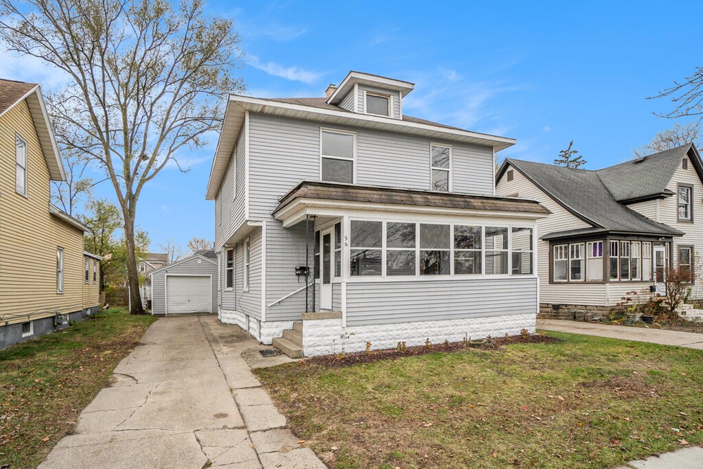 front facade with an outbuilding, a garage, and a front yard