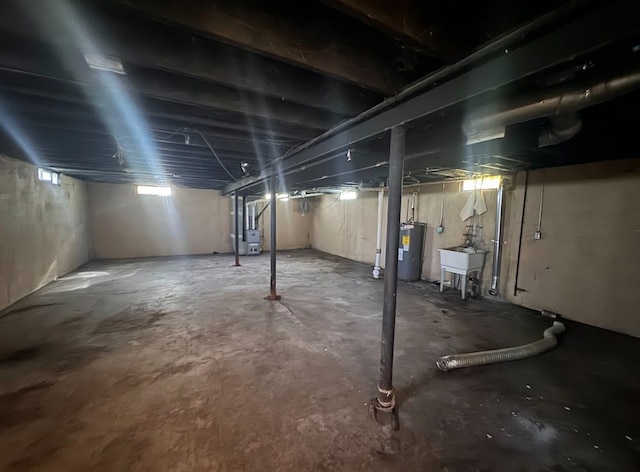 basement featuring electric water heater and sink