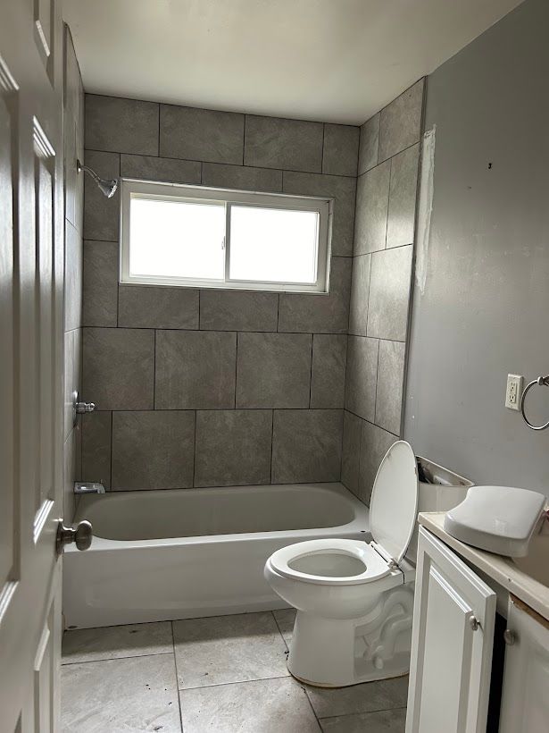 full bathroom featuring vanity, toilet, and tiled shower / bath combo