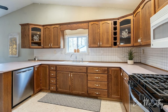 kitchen with lofted ceiling, sink, decorative backsplash, light tile patterned floors, and stainless steel appliances