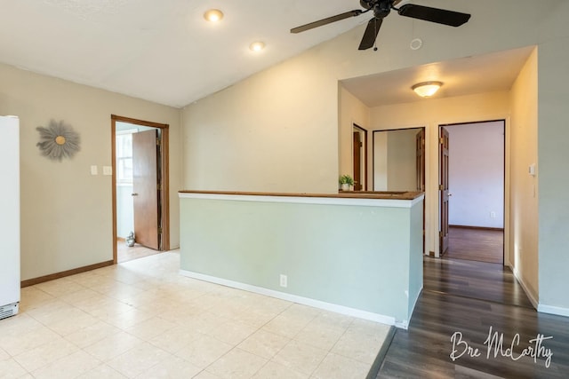 empty room with light hardwood / wood-style floors, vaulted ceiling, and ceiling fan