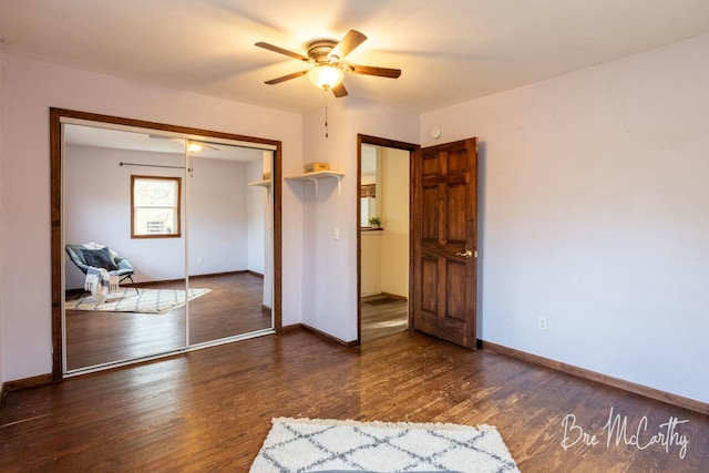 unfurnished bedroom with dark hardwood / wood-style flooring, a closet, and ceiling fan