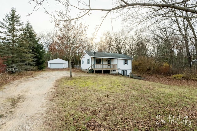 view of front of property with an outbuilding, a garage, a front lawn, and covered porch