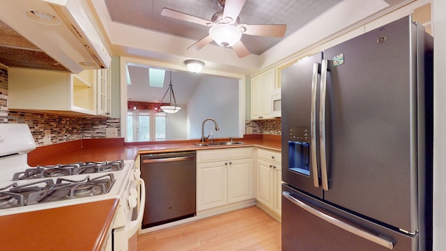 kitchen with decorative backsplash, appliances with stainless steel finishes, pendant lighting, and sink