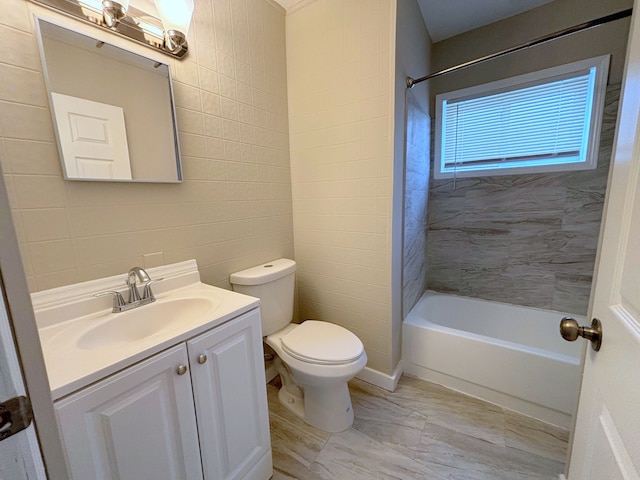 full bathroom with shower / bathing tub combination, vanity, toilet, and tile walls