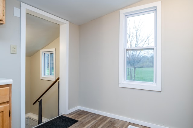 additional living space featuring lofted ceiling and light wood-type flooring