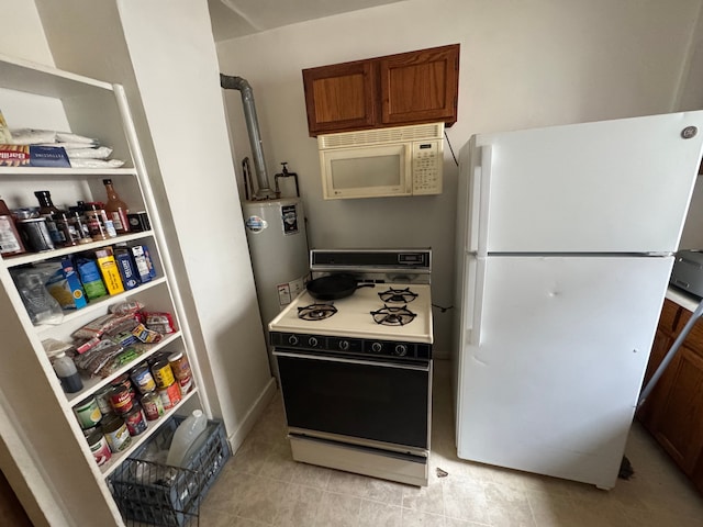 kitchen featuring light tile patterned floors, white appliances, and water heater