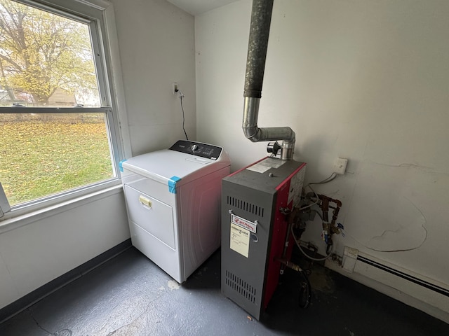 clothes washing area featuring a healthy amount of sunlight, baseboard heating, and washer / clothes dryer