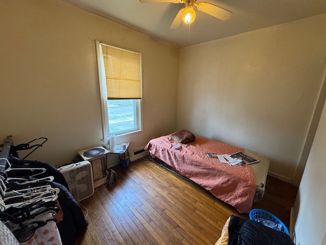 bedroom with ceiling fan, wood-type flooring, and a baseboard radiator