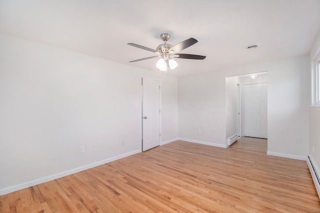 spare room featuring a baseboard radiator, ceiling fan, and light hardwood / wood-style flooring