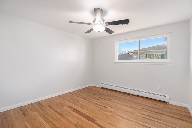 spare room featuring baseboard heating, ceiling fan, and light hardwood / wood-style flooring